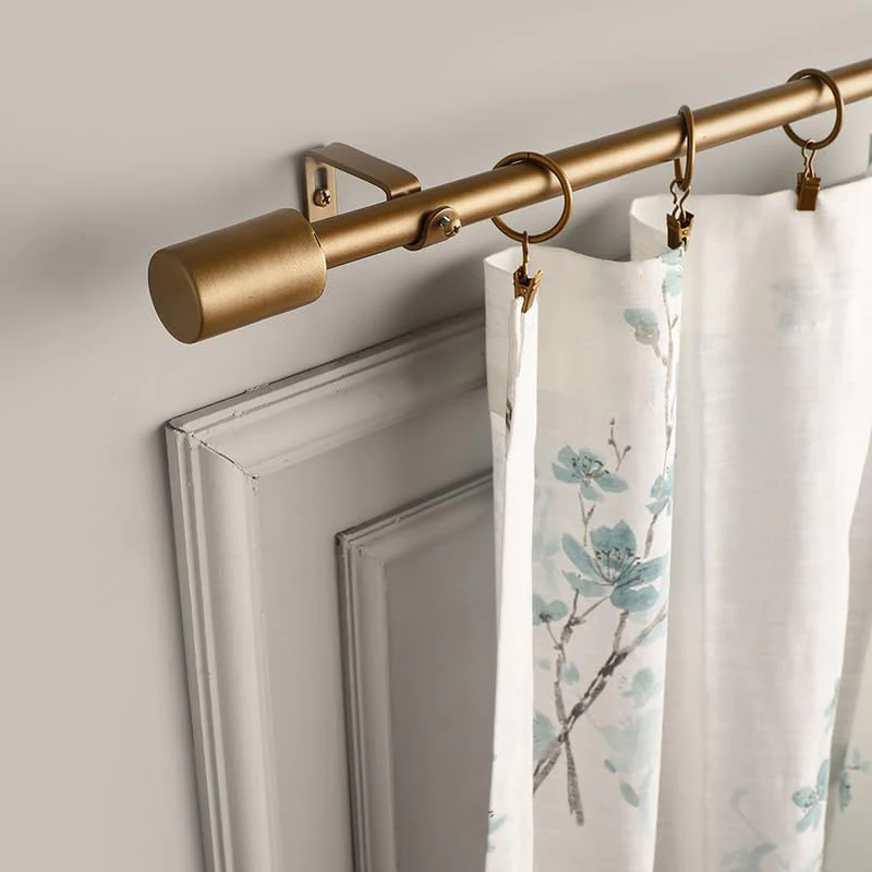 Gold metal curtain rod install with printed curtains in Dubai home